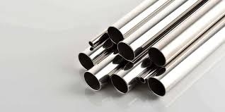 Polished stainless steel pipes stacked on a gray surface.
